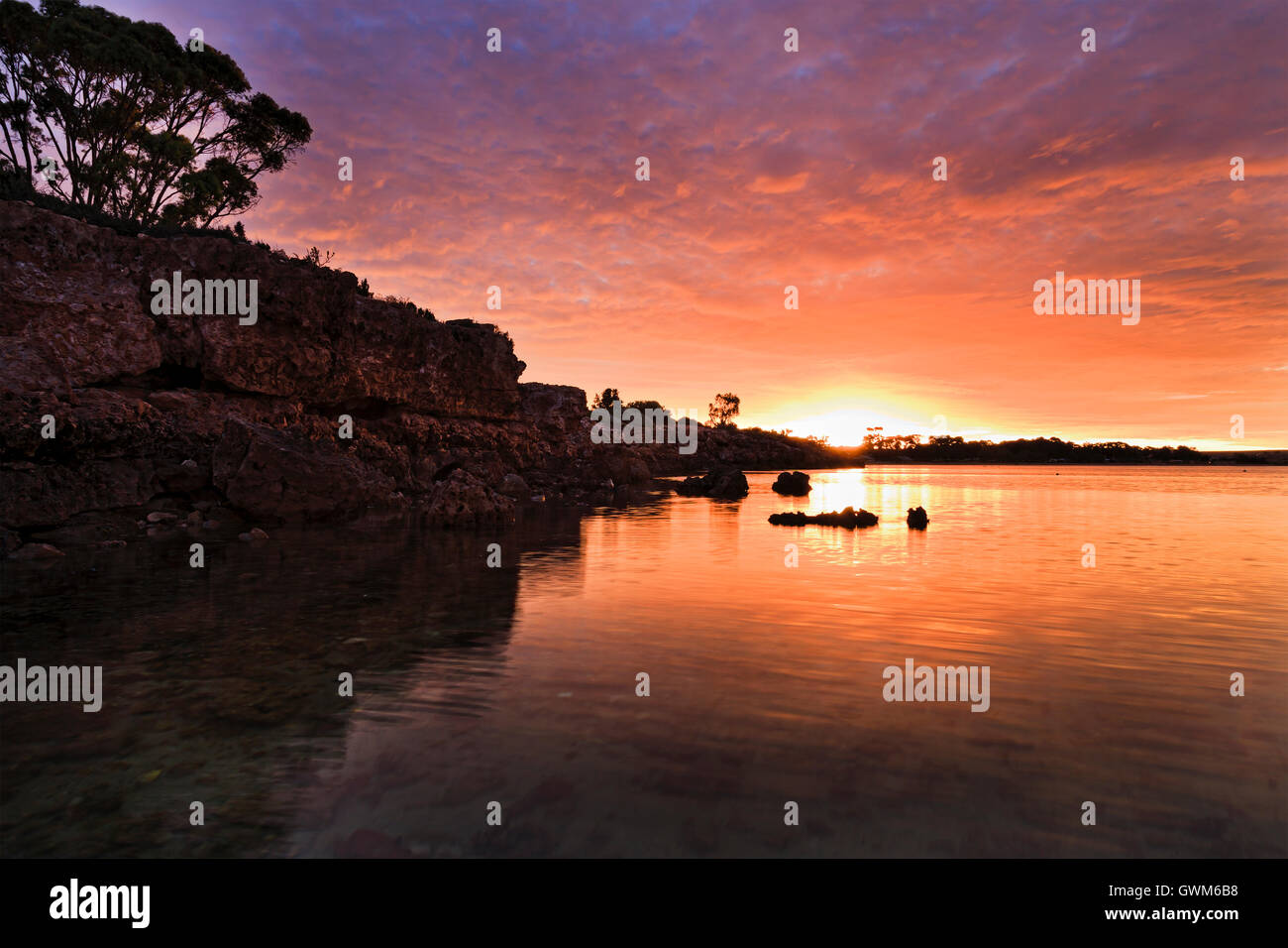 Bunte orange warm untergehende Sonne über Horizont im Westen bei Streaky Bay Town auf Great Australian Bight in South Australia. Stockfoto