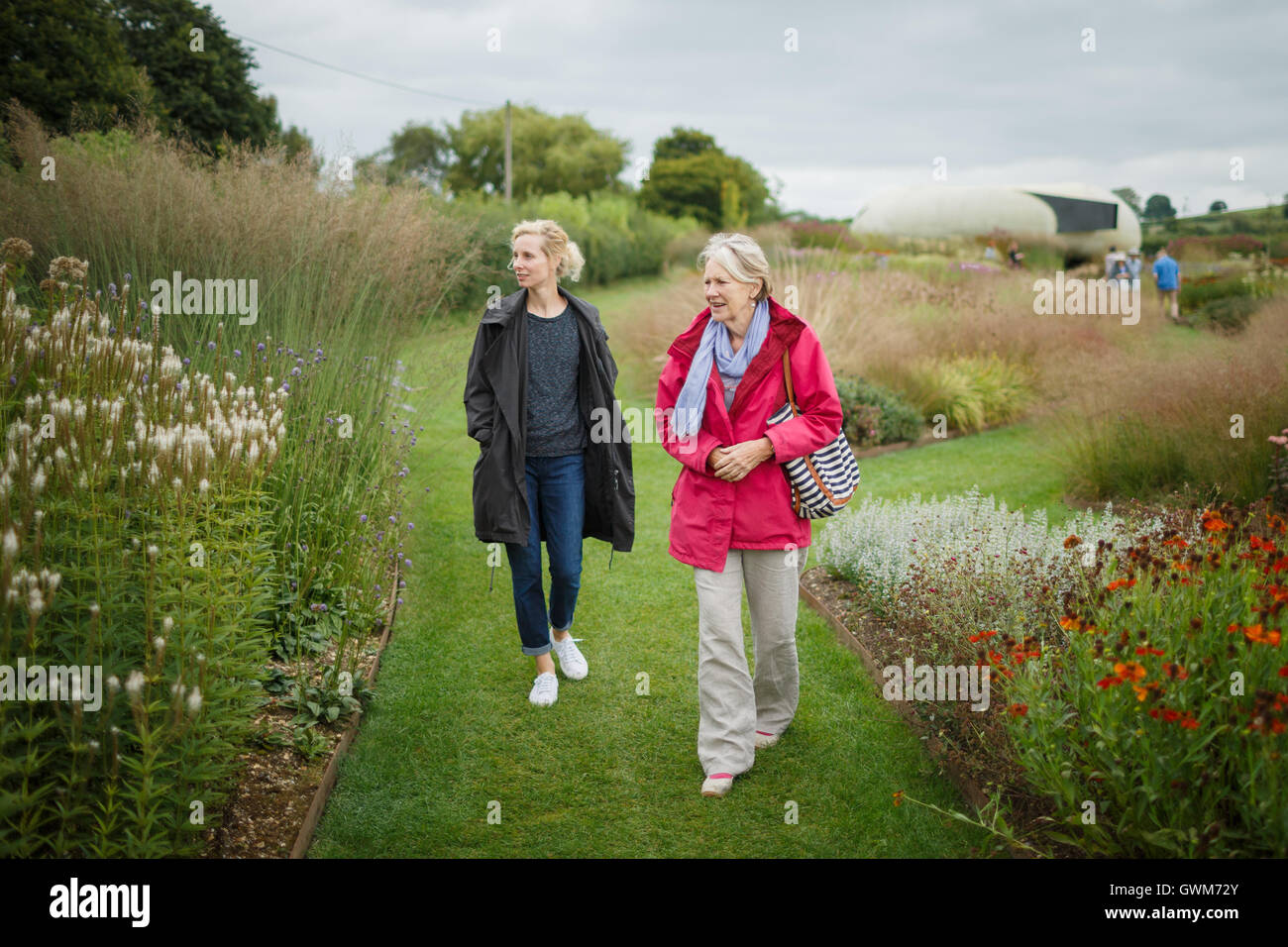 2 Frauen, die einen Garten herumlaufen Stockfoto