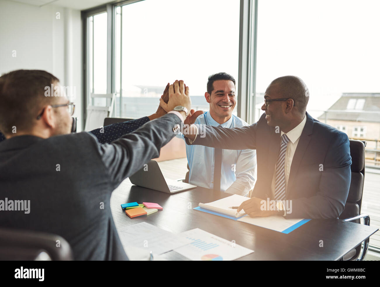 Multiethnische erfolgreiches Team gratulieren einander auf eine Leistung geben eine hohe Fives gestikulieren mit den Händen Stockfoto