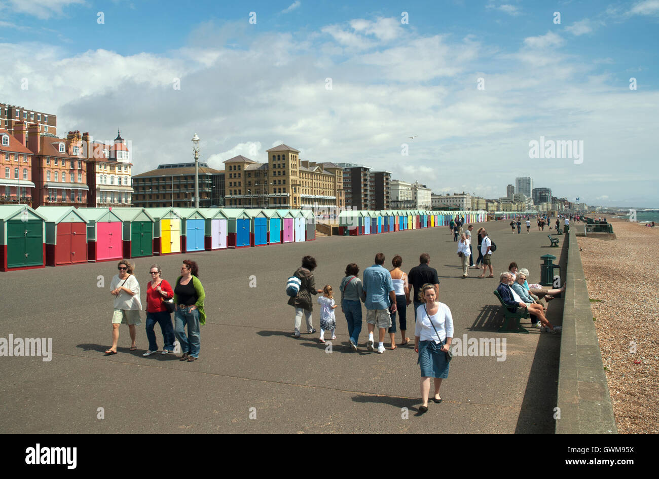 Strandhütten und Fußgänger auf dem Vorland von Brighton und Hove, East Sussex, UK Stockfoto