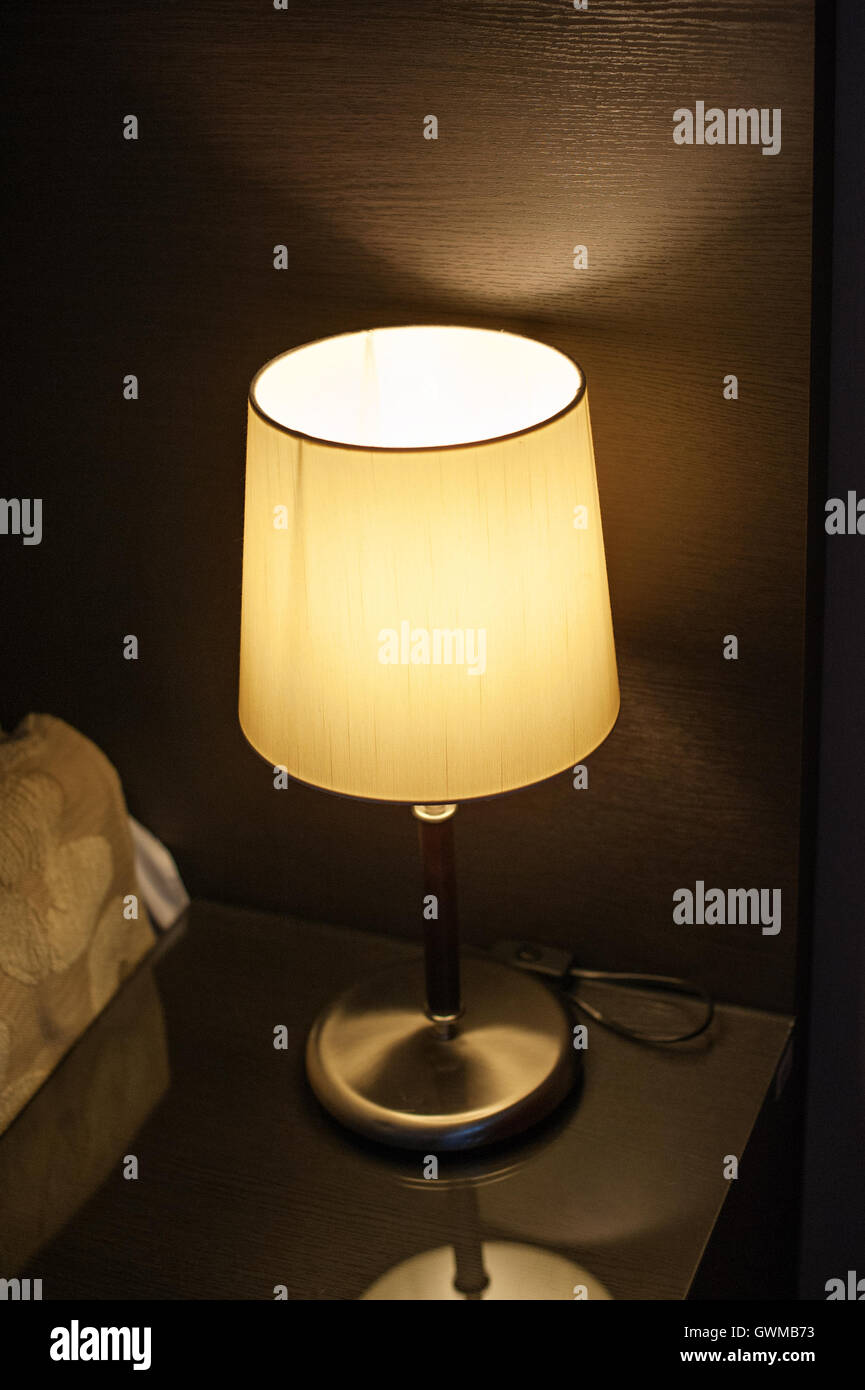 Lampe auf dem Nachttisch im Schlafzimmer neben dem Bett Stockfoto