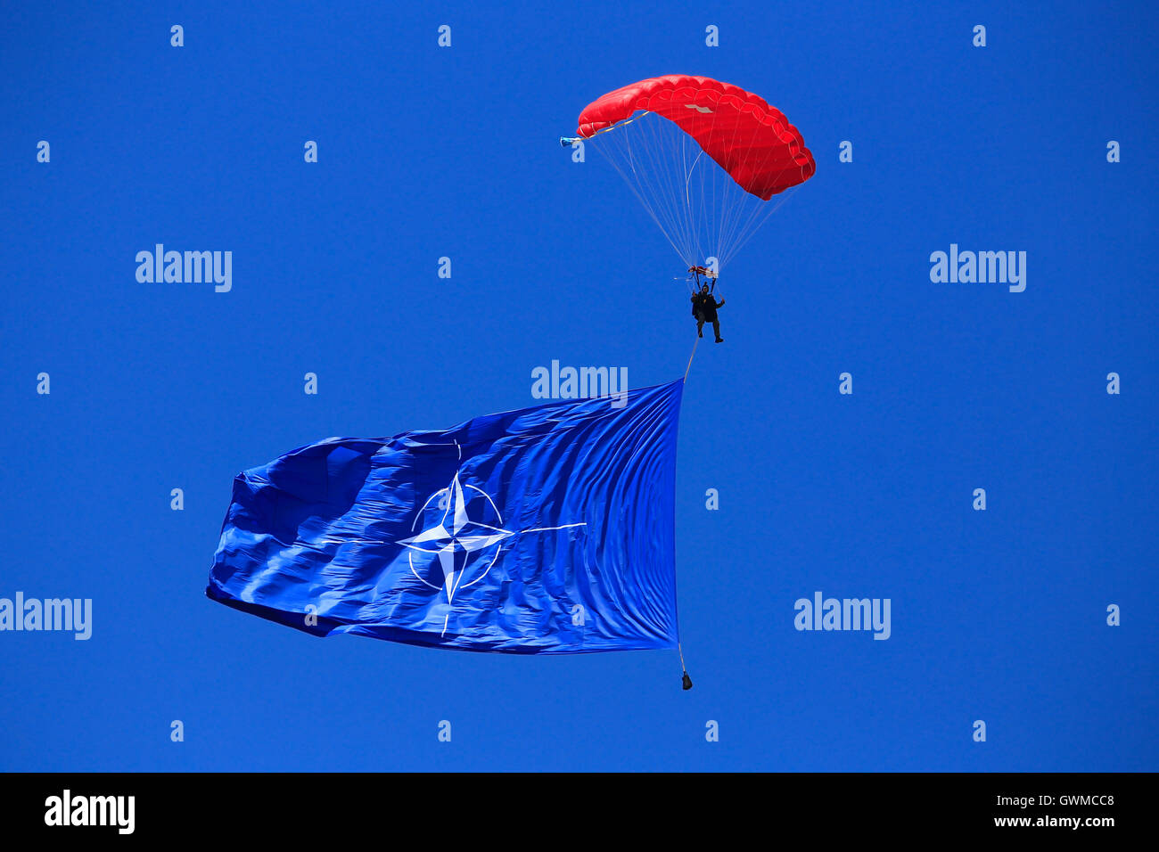 Fallschirmspringer mit Nato-Flagge in der Luft am SIAF Airshow in Sliac, Slowakei Stockfoto