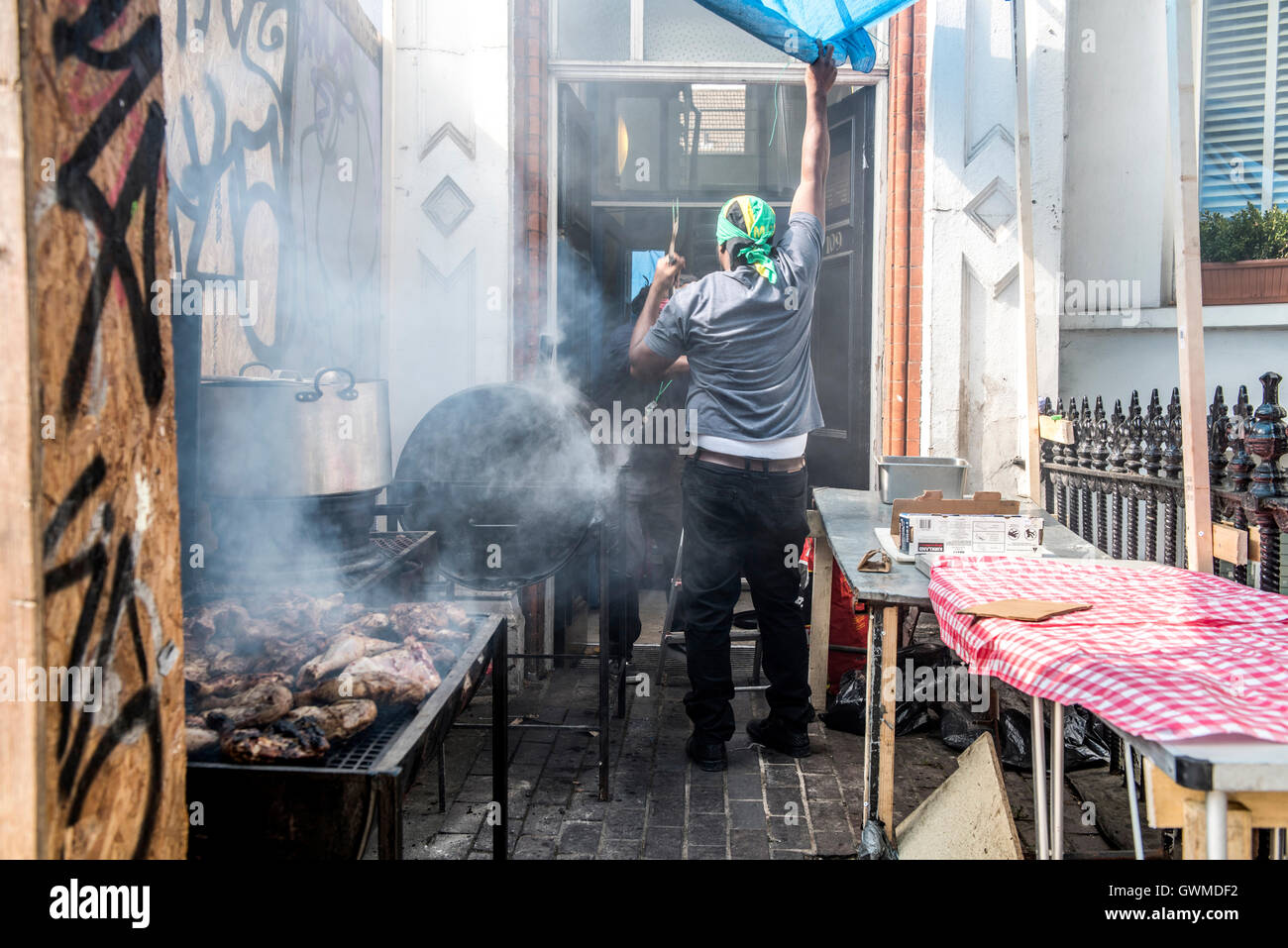 Einheimische Küche und Verkauf karibisches Essen außerhalb ihrer Häuser während der Notting Hill Carnival Stockfoto