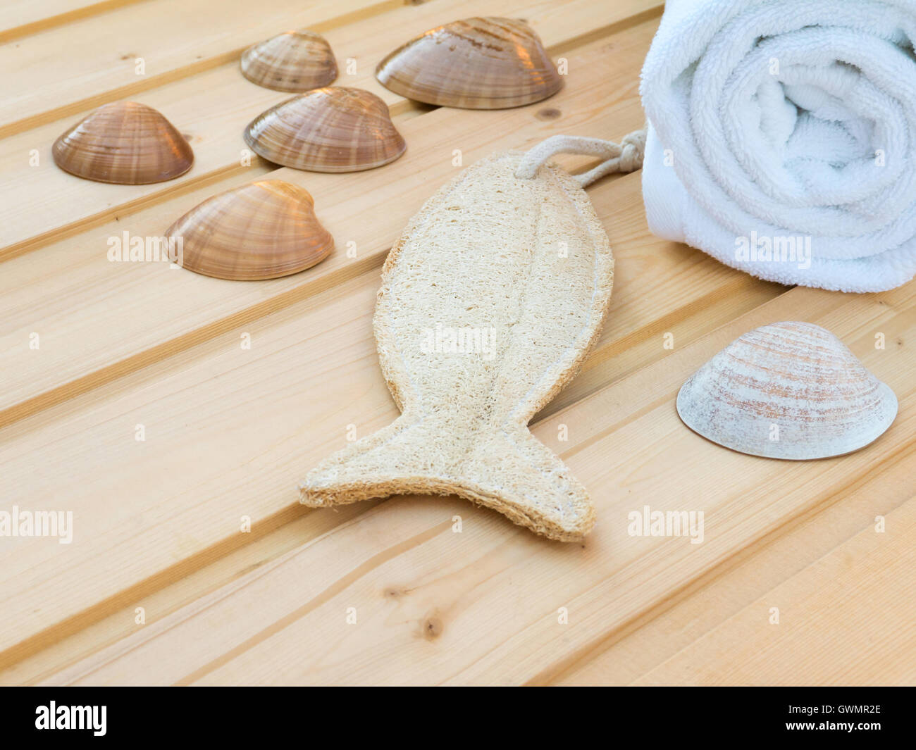 Weißes Handtuch, Muscheln und Fisch geformt Wisp auf den Holzplanken Stockfoto