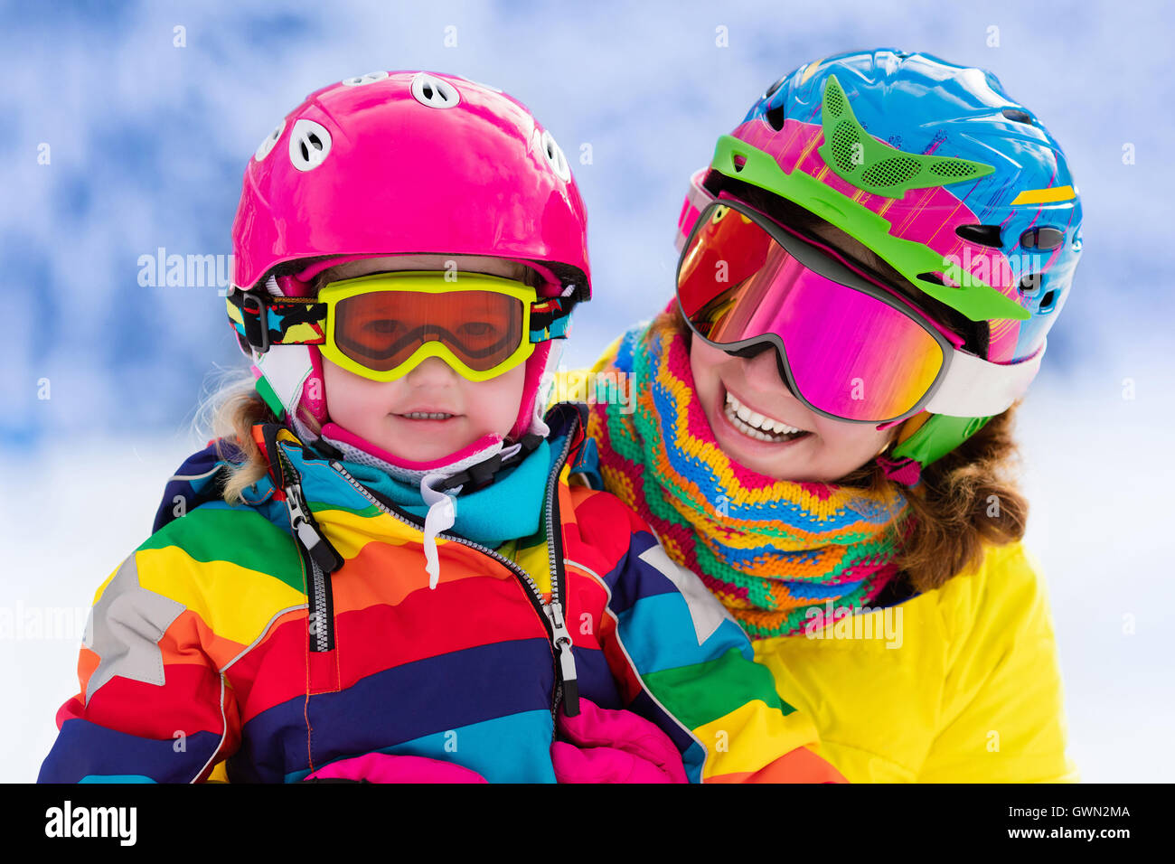 Mutter und Kind Skifahren in den Alpen. Aktive Mutter und Kleinkind Kind mit Helm, Schutzbrille und Polen. Ski Unterricht f Stockfoto