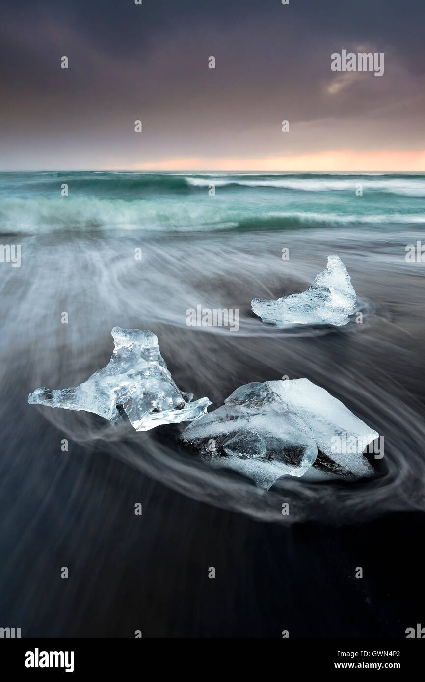 Eisberge am vulkanischen Strand Fellsfjara bei Sonnenaufgang, in der Nähe von Jokulsarlon, Südisland Stockfoto