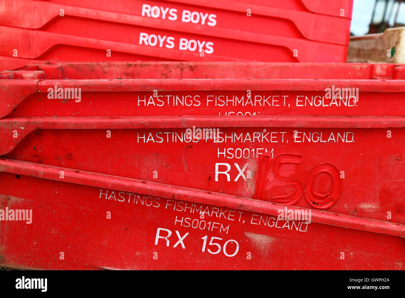 Stapel von roten Plastikfische Kisten im Fischereihafen, Hastings, East Sussex, England Stockfoto