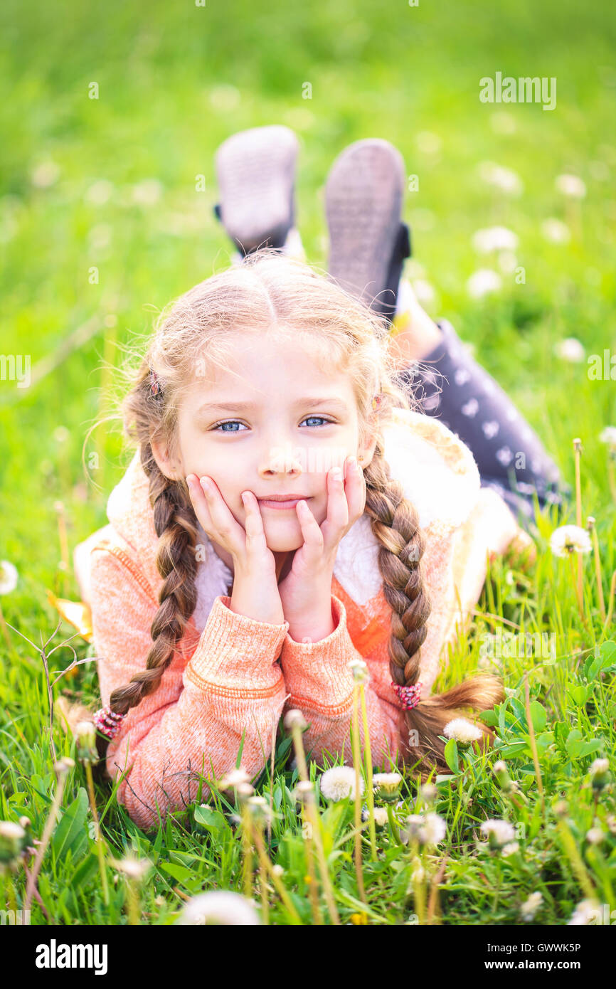 Niedliche kleine Mädchen auf der Wiese im strahlenden Sommertag Stockfoto