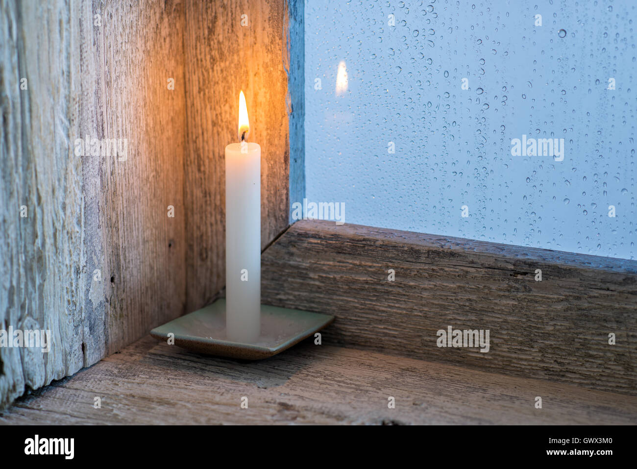 Kerze auf dem Fensterbrett eines Fensters, Regen draußen. Textfreiraum Stockfoto Kerze auf dem Fensterbrett eines Fensters, Regen draußen. Textfreiraum Stockfoto