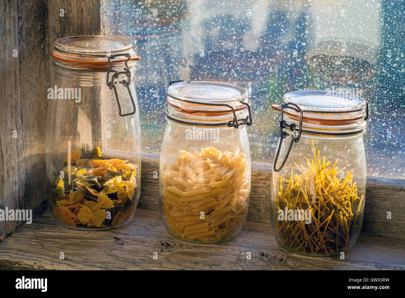 verschiedenen rohen Nudeln in einem Glas in der Fensterbank Stockfoto