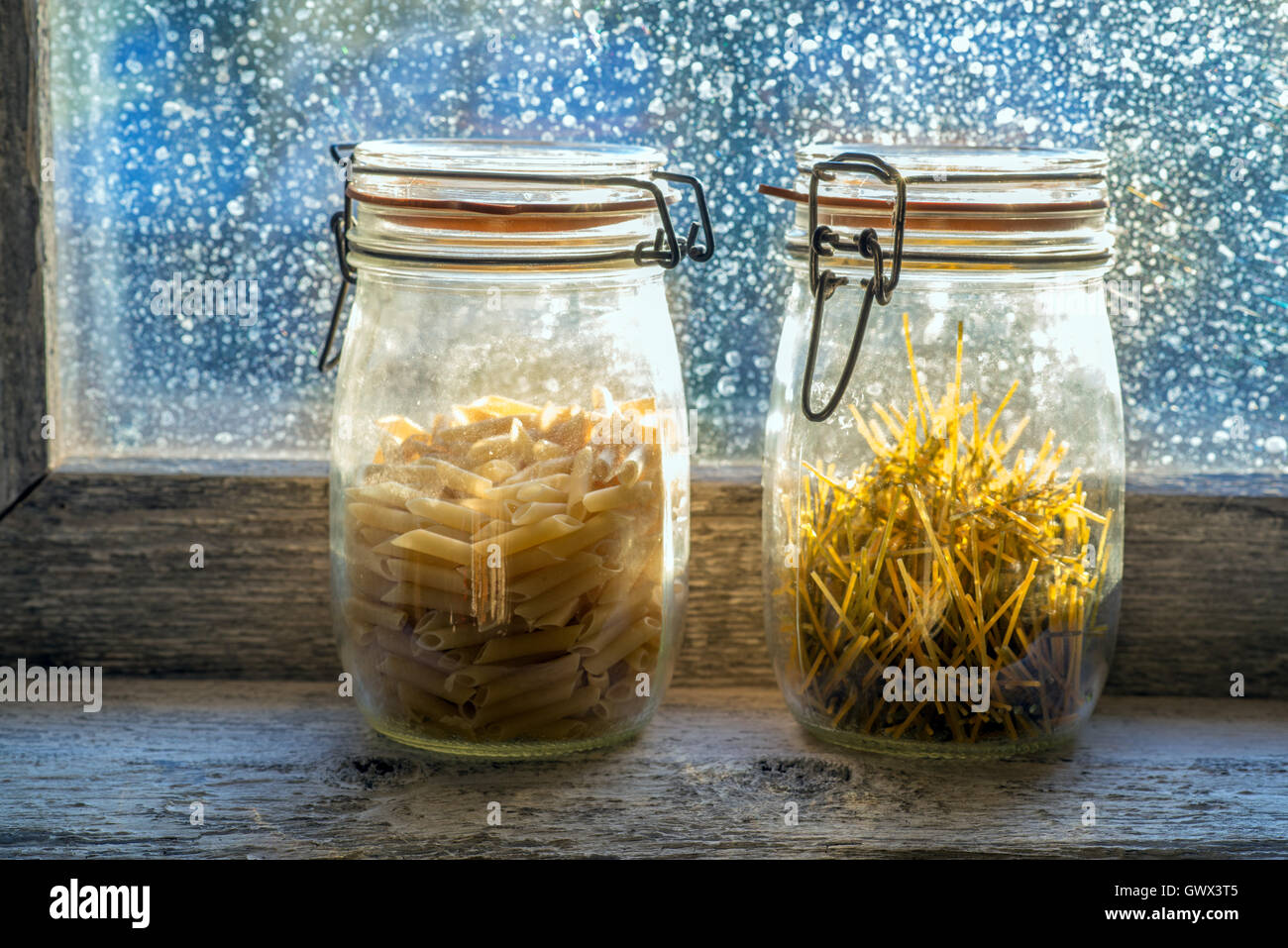 verschiedenen rohen Nudeln in einem Glas in der Fensterbank Stockfoto