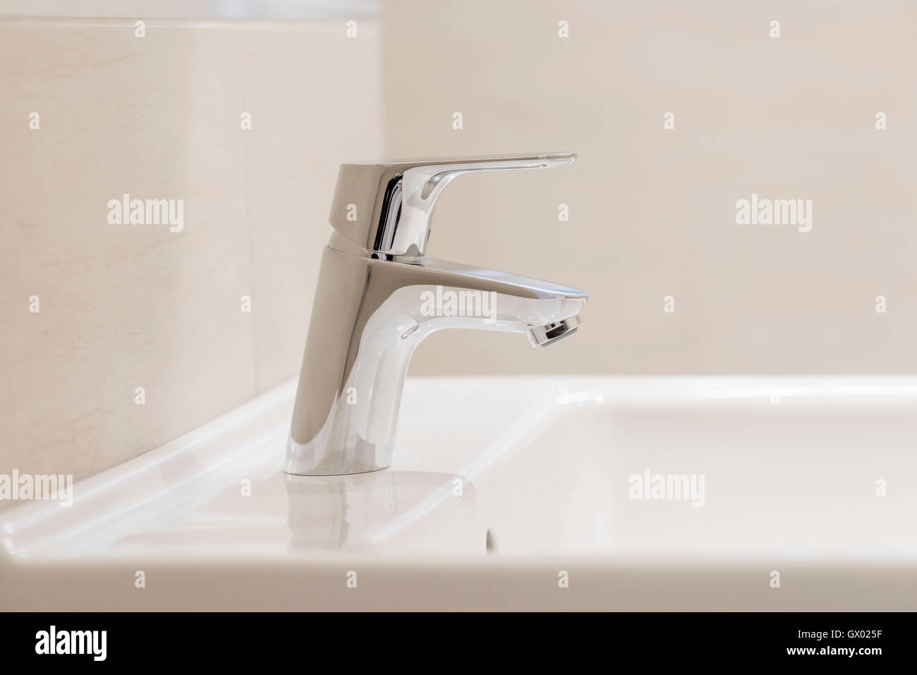 Poliertem Chrom Mischbatterie auf weißen Waschbecken im Badezimmer Stockfoto