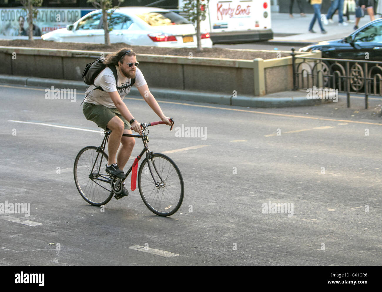 Ein langhaariger Mann ist ein Fahrrad fährt. Stockfoto