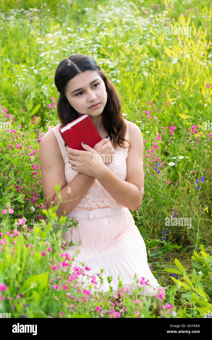 Romantisches Mädchen mit roten Buch auf Natur Stockfoto