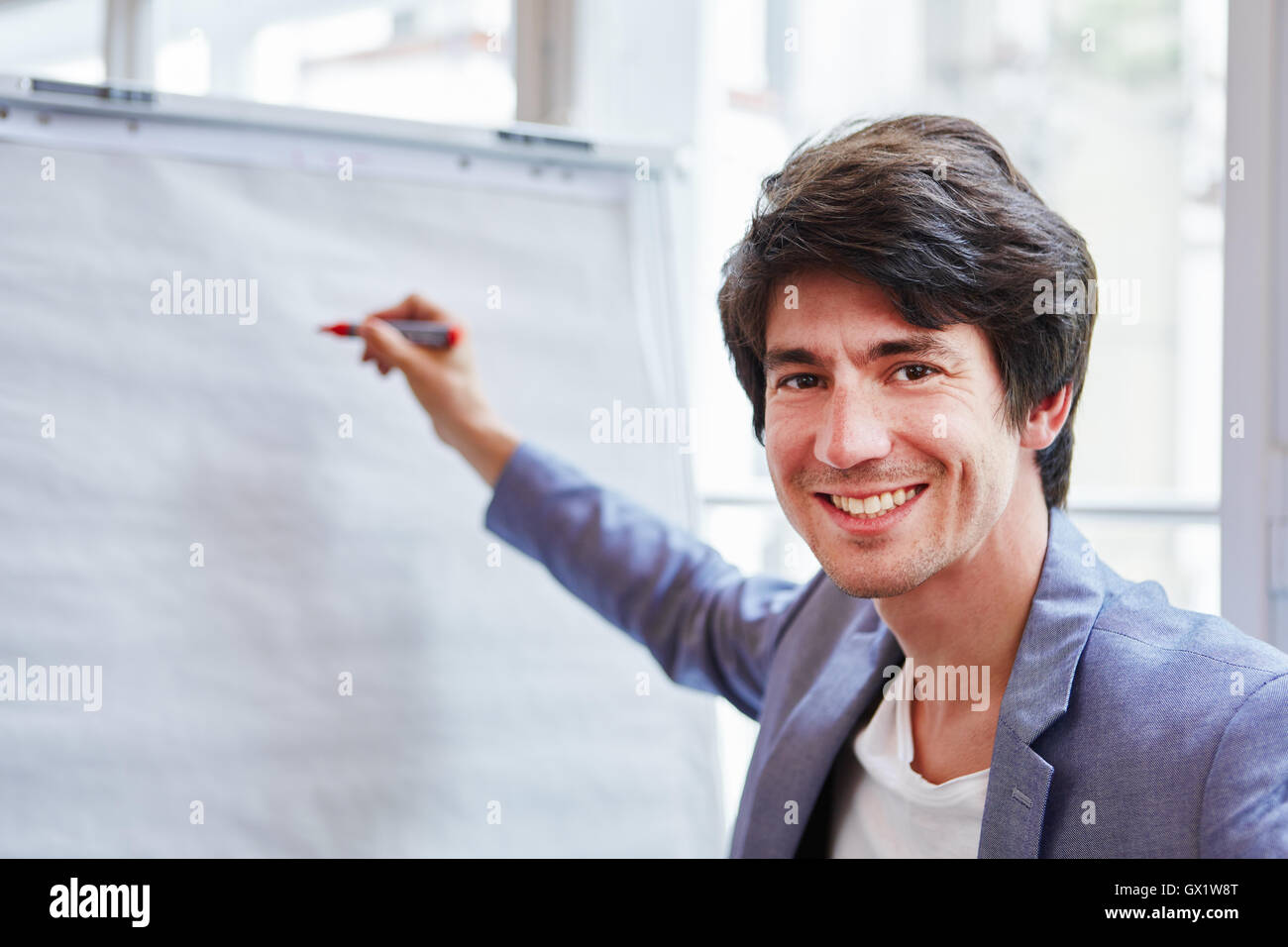 Erfolgreicher Geschäftsmann mit Stift in einer Präsentation mit whiteboard Stockfoto