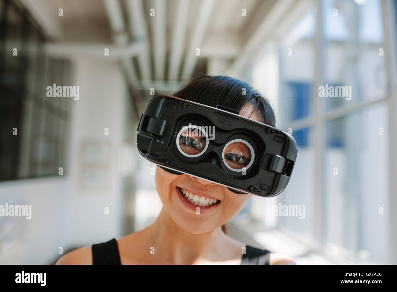 Nahaufnahme Schuss der fröhliche junge Frau, die virtual-Reality-Brille tragen. Weibchen mit VR Kopfhörer Anschlussvorrichtung. Stockfoto