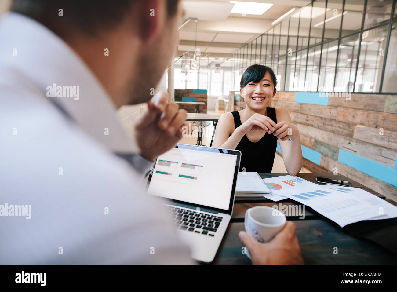 Aufnahme von zwei Kollegen arbeiten im Büro diskutieren. Lächelnde junge Asiatin mit Office Manager treffen. Stockfoto