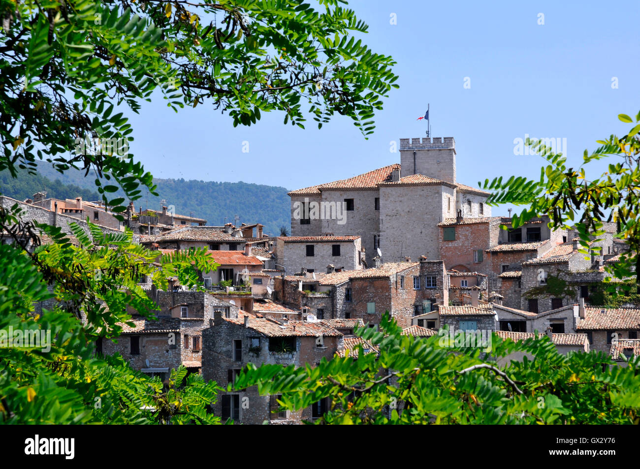 Dorf von Tourrettes-Sur-Loup im Südosten Frankreichs mit Blätter im Vordergrund, Region Provence, Departement Alpes-Maritimes Stockfoto