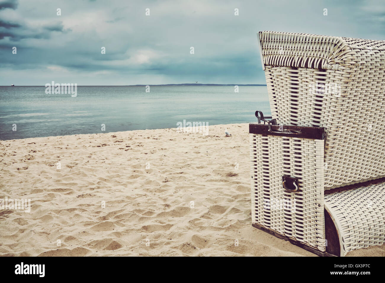 Retro stilisierte Kapuzen Korbstuhl Korb an einem leeren Strand. Stockfoto