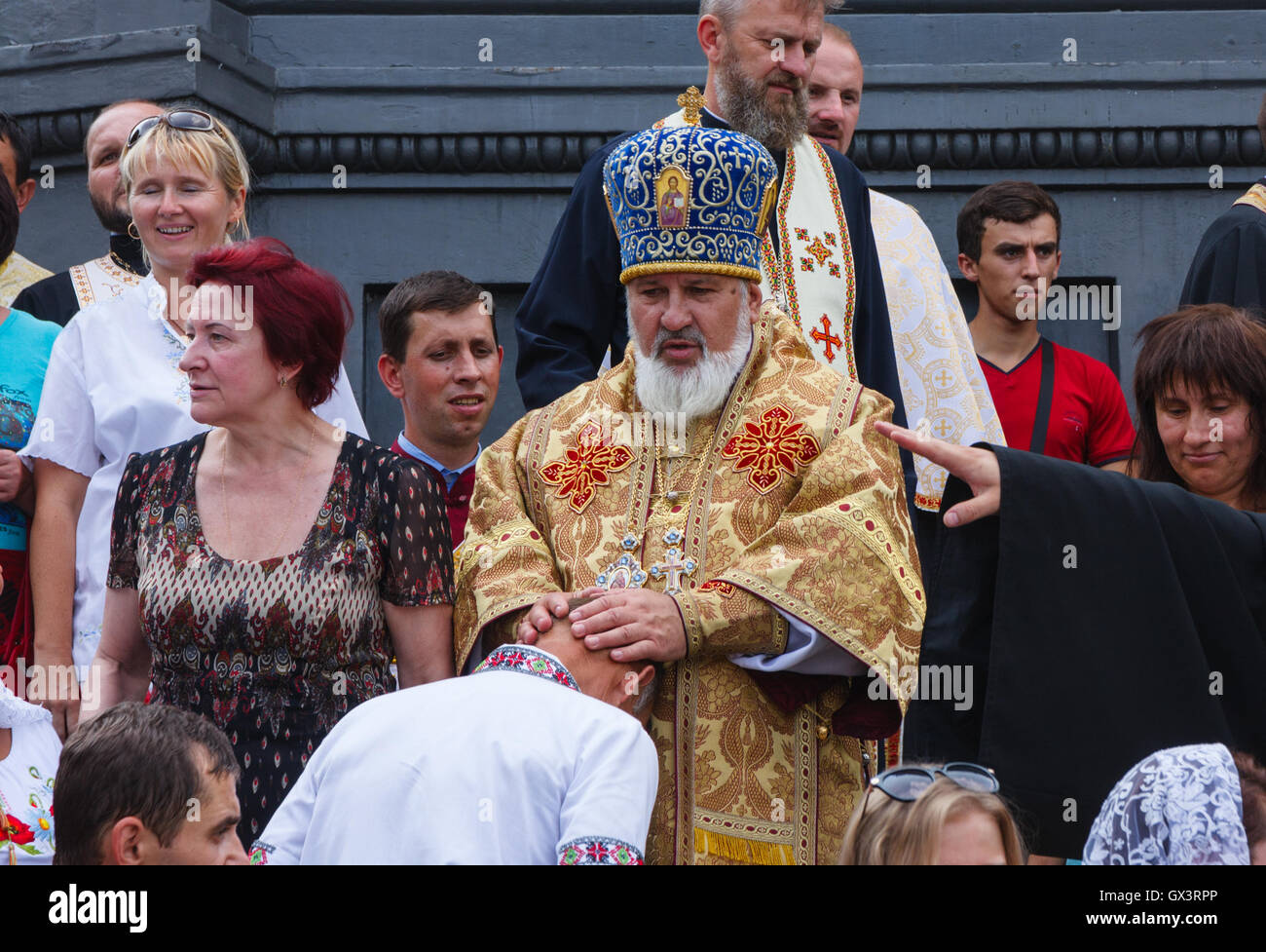 Ein Mann ist bei einem Umzug von einem Kleriker des Kiewer Patriarchats Ukraine orthodoxe Kirche (UOC) gesegnet. Stockfoto