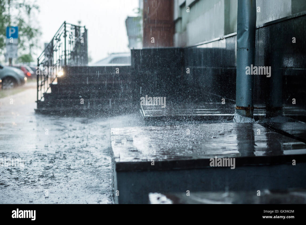 Regen Sie, Wasser fließt aus Metall Fallrohr während einer Überschwemmung. Konzept der Schutz vor starkem Regen. Stockfoto