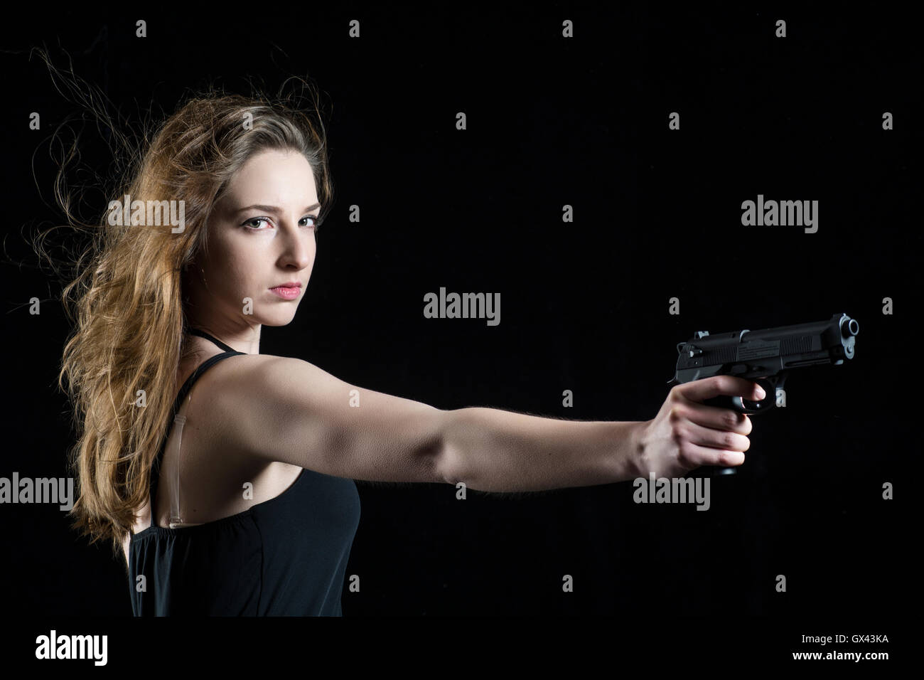 Schwere Frau, die eine Waffe Stockfoto