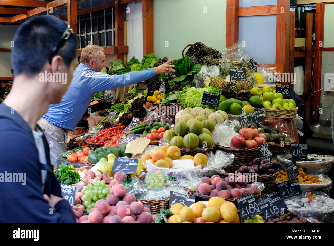 Ein Mann kaufen Gemüse aus Obst und Gemüse Stall im Borough market Stockfoto