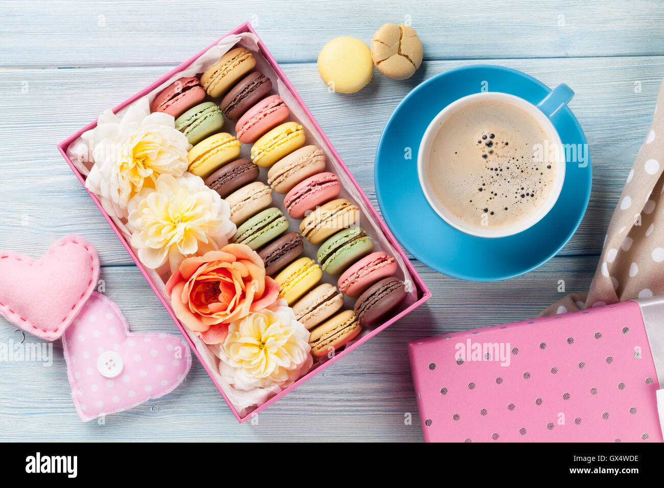 Bunte Makronen und Kaffee am Tisch aus Holz. Süßen Macarons in Geschenk ...