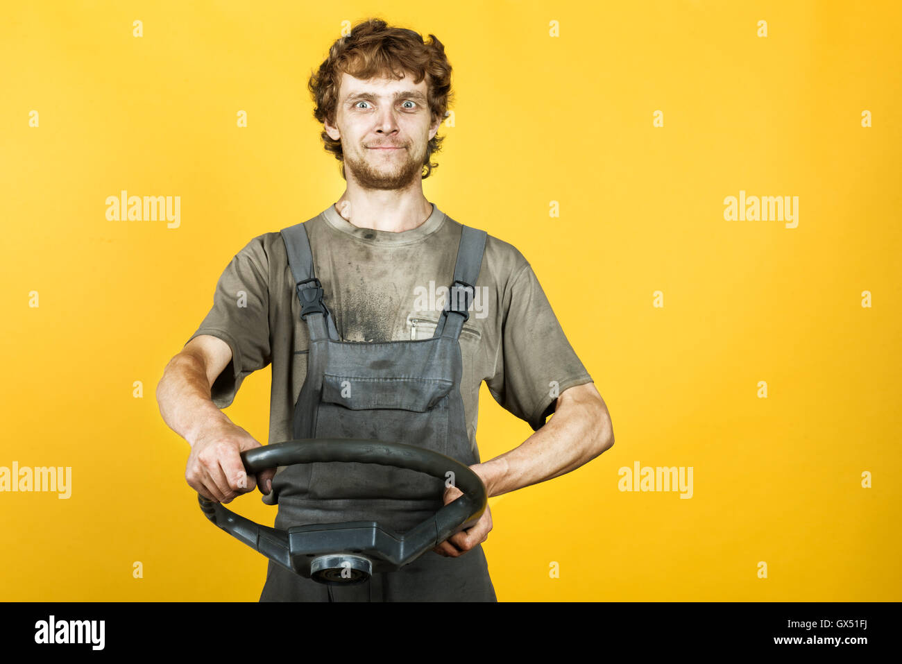 Gut aussehend lächelnd Mechaniker hält das Rad gelb Stockfoto