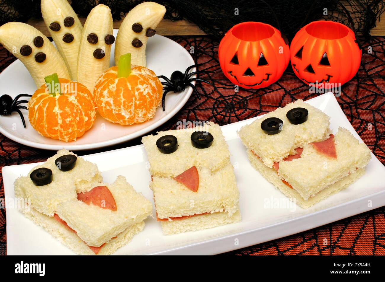 Gesunden Halloween-Süßigkeiten, Monster-Sandwiches, Banane Geister und orange Kürbisse mit Urlaub Dekor Stockfoto