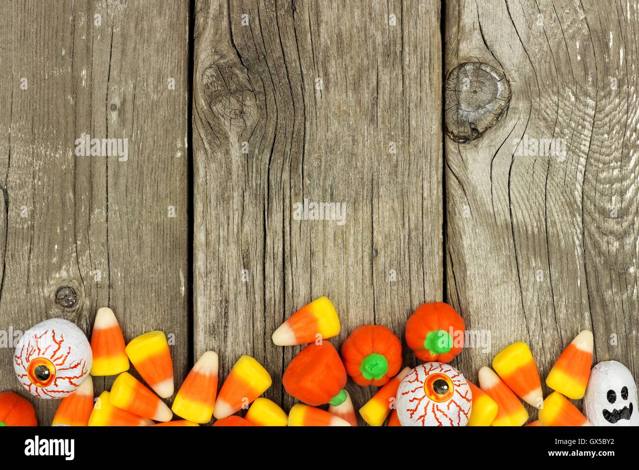 Halloween Süßigkeiten untere Rahmenlinie vor einem rustikalen Holz Hintergrund Stockfoto