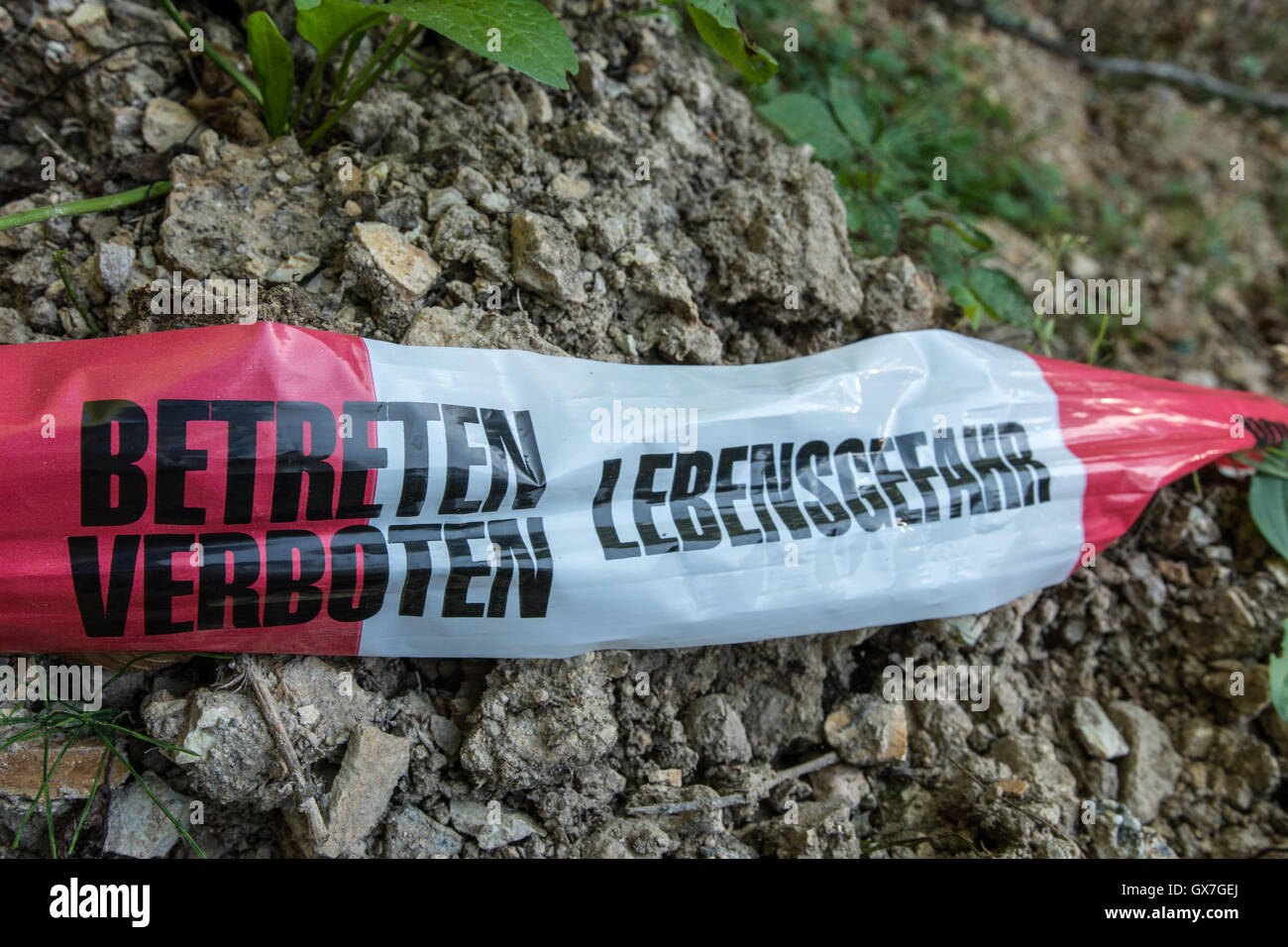 Absperrband vor riesiges Loch im Wald Stockfoto