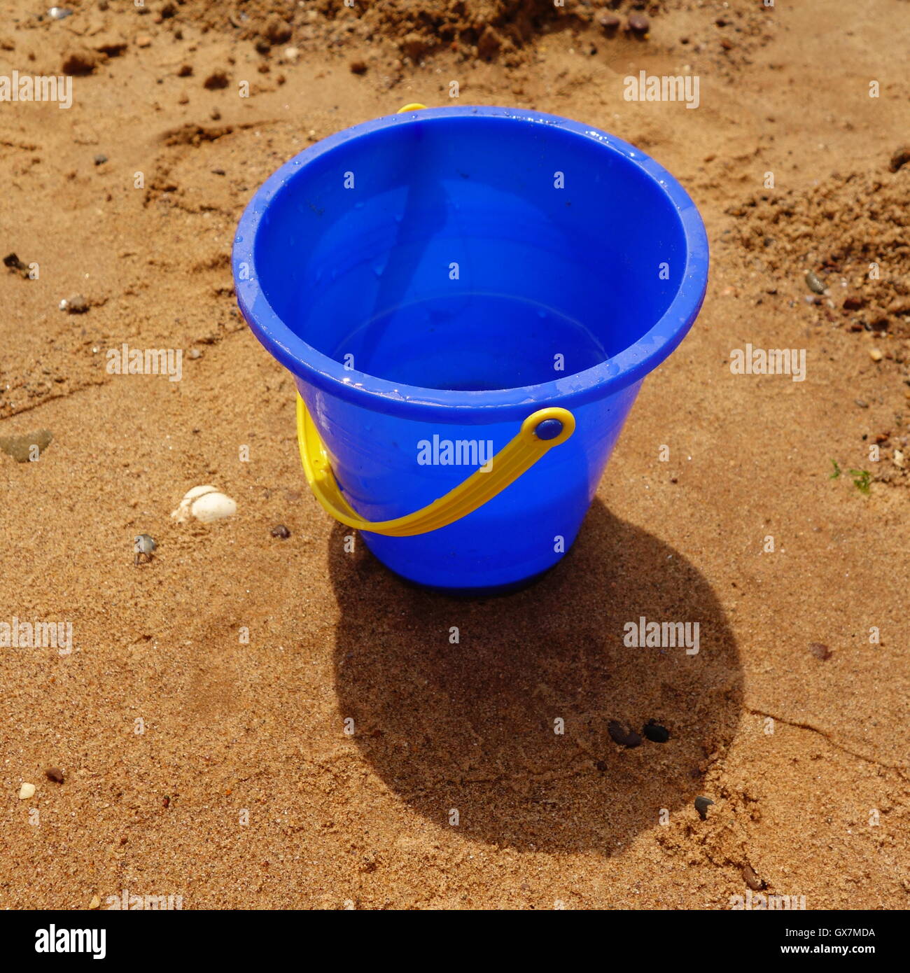 Blaue Kunststoff-Eimer am Strand Stockfoto