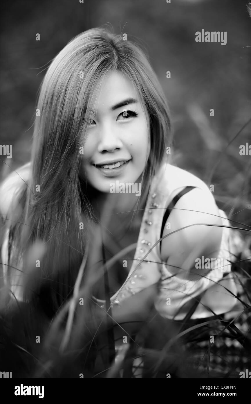 schwarz / weißes Porträt Thai schöne Mädchen sitzen auf dem Rasen Stockfoto