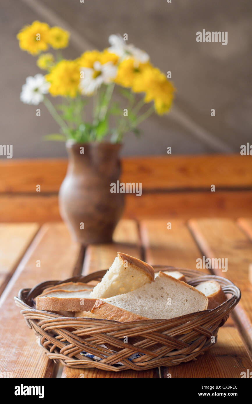 Weidenkorb mit Brot und Blumen Stockfoto