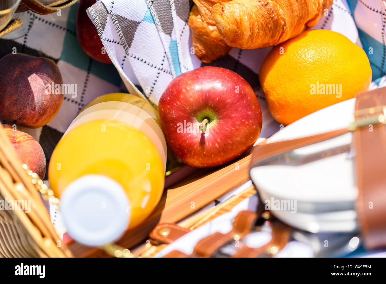 Saftflasche, Pfirsich, Apfel, Orange und Croissant In Essen-Picknick-Korb Stockfoto