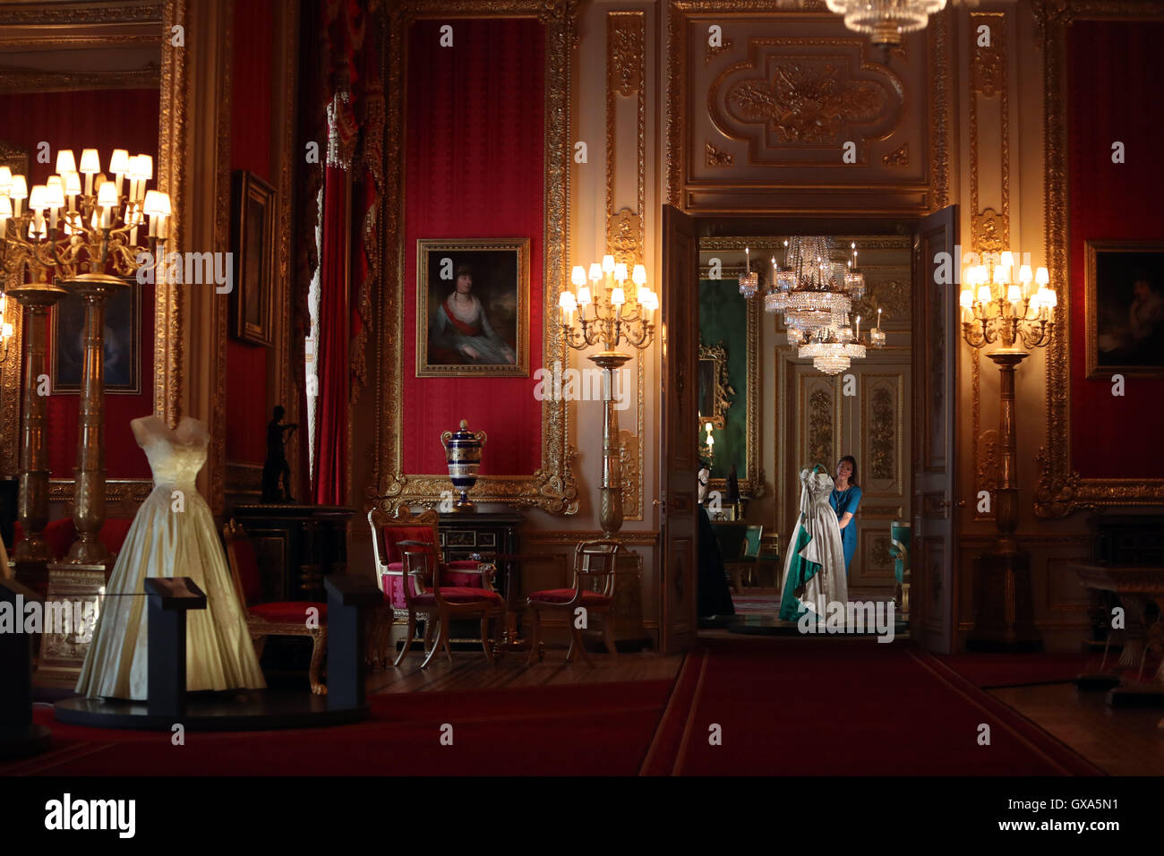 Die Kuratorin Caroline de Guitaut arrangiert im Green Drawing Room ein Abendkleid, das die Königin trägt, während einer Pressevorschau für die Ausstellung „A Reign: 90 Years of Style from the Queen's Garderobe“ im Windsor Castle in Bekshire. Stockfoto