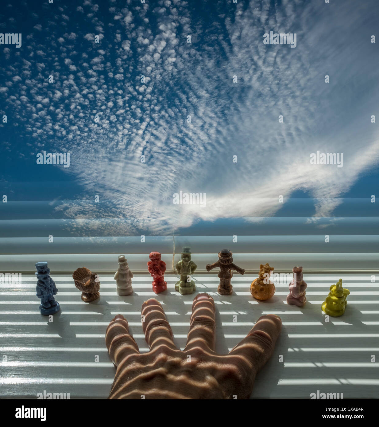Hand, Porzellanfiguren und Wolken Stockfoto