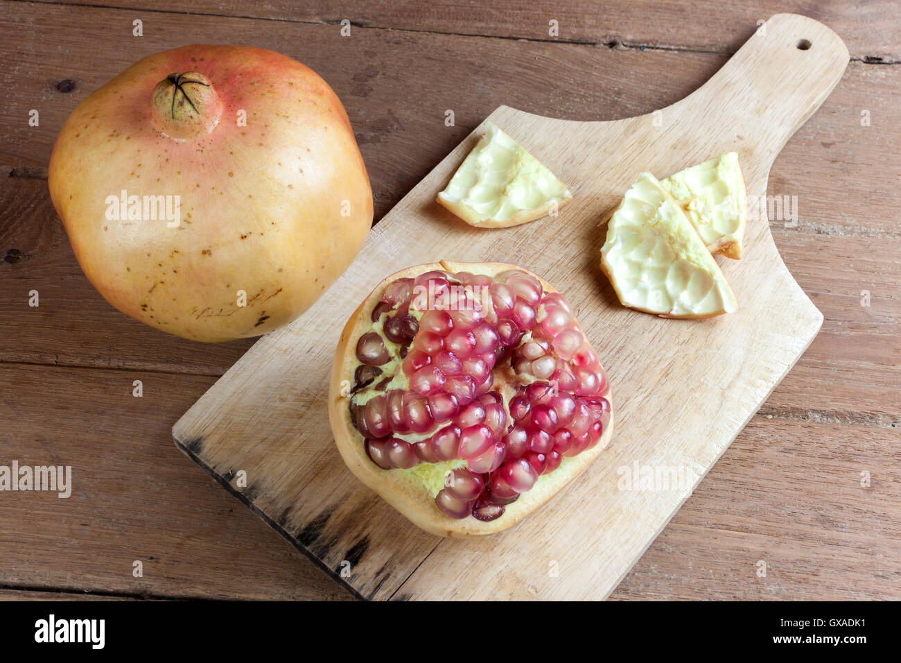 Granatapfel-Frucht-Schnitt sezieren auf hölzernen Hintergrund. Stockfoto