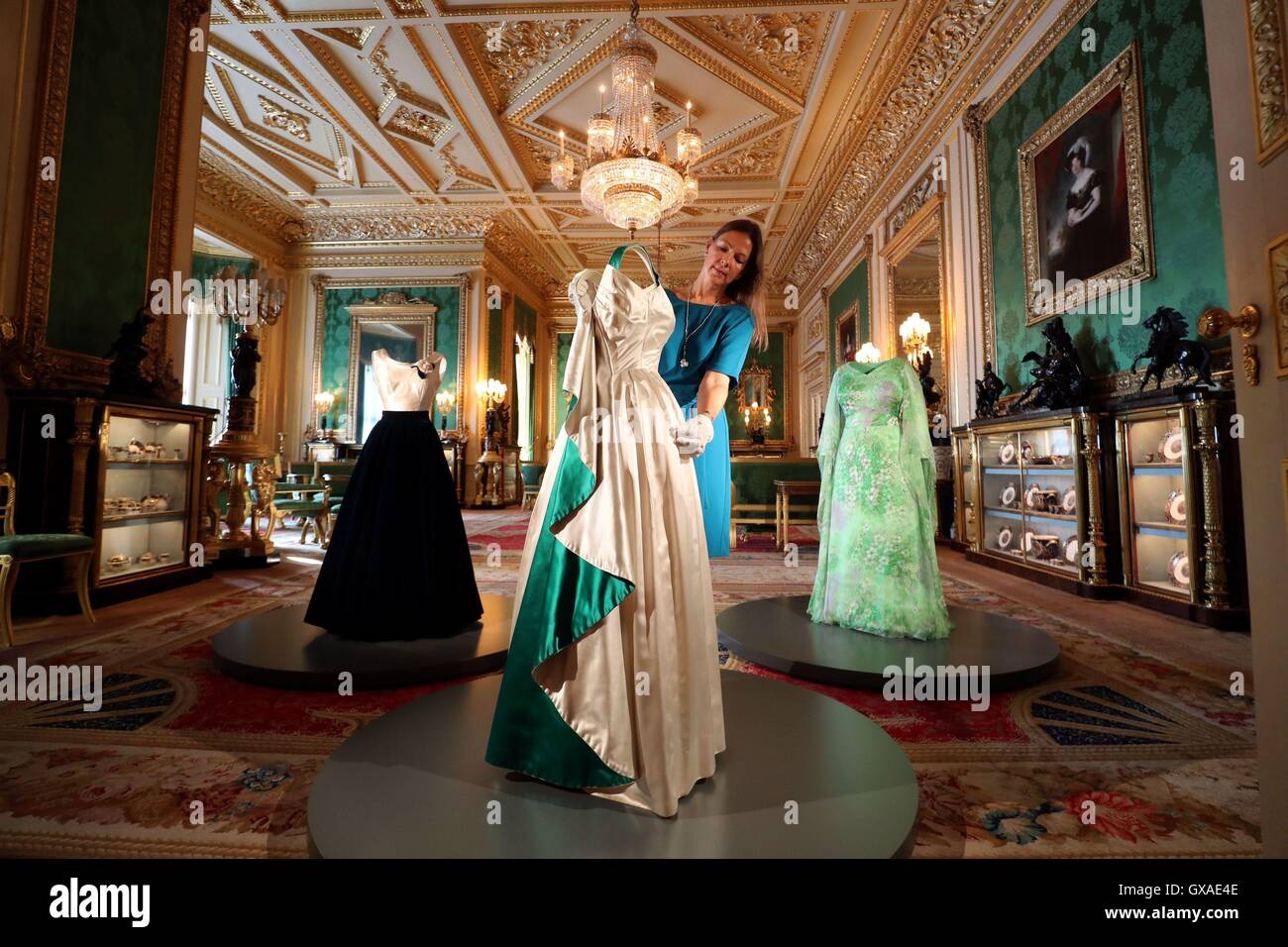 Die Kuratorin Caroline de Guitaut arrangiert im Green Drawing Room ein Abendkleid, das die Königin trägt, während einer Pressevorschau für die Ausstellung „A Reign: 90 Years of Style from the Queen's Garderobe“ im Windsor Castle in Bekshire. Stockfoto
