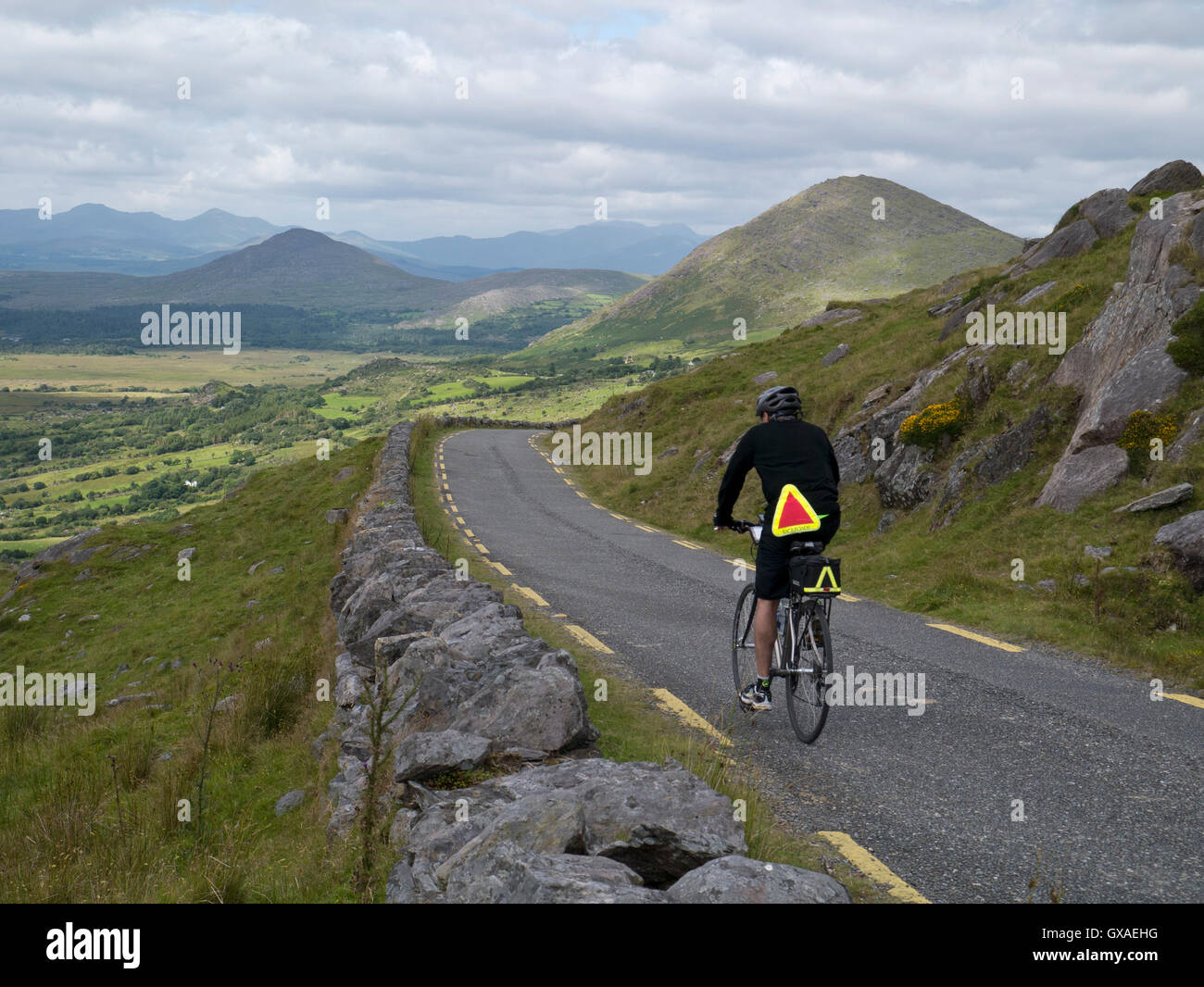 Männlicher Radfahrer, der vom Healy Pass, Grafschaft Kerry, absteigt Stockfoto