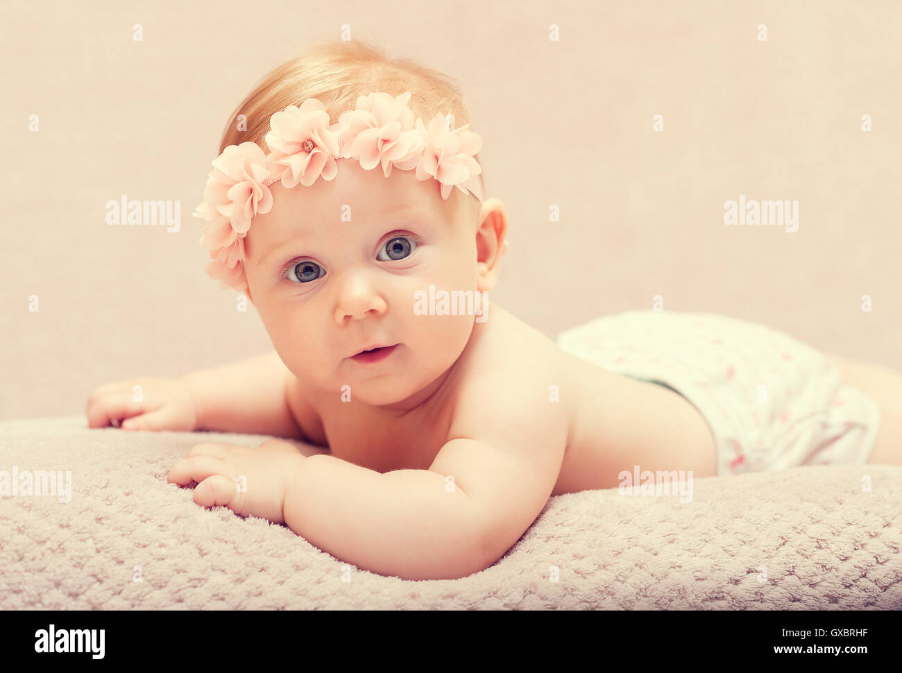 Porträt des kaukasischen Neugeborenen mit rosa Blume Wollmütze Stockfoto