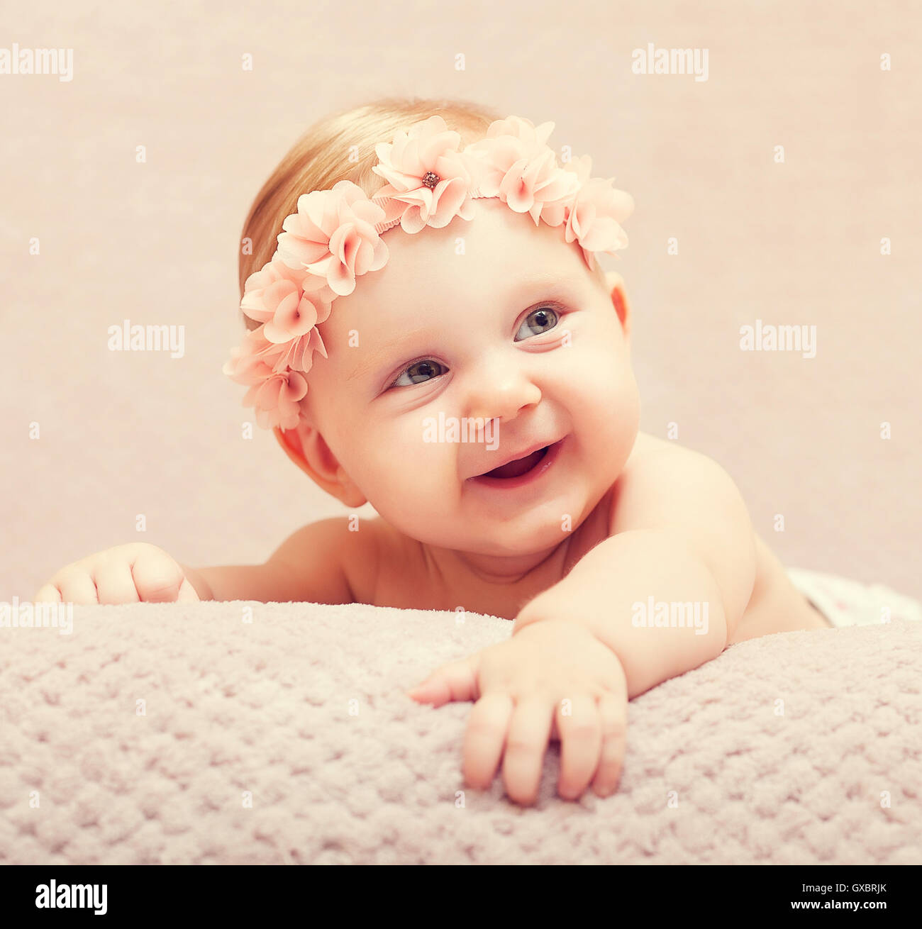Porträt des kaukasischen Neugeborenen mit rosa Blume Wollmütze Stockfoto