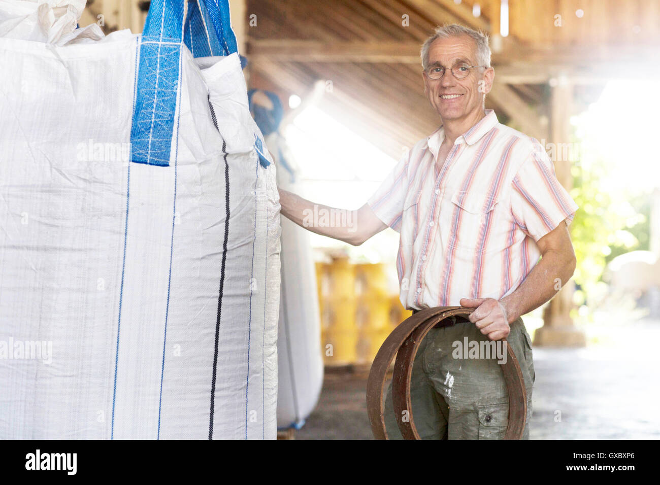 Porträt von männlichen Miller mit Vollkorn Sack Weizen-Mühle-Lager Stockfoto