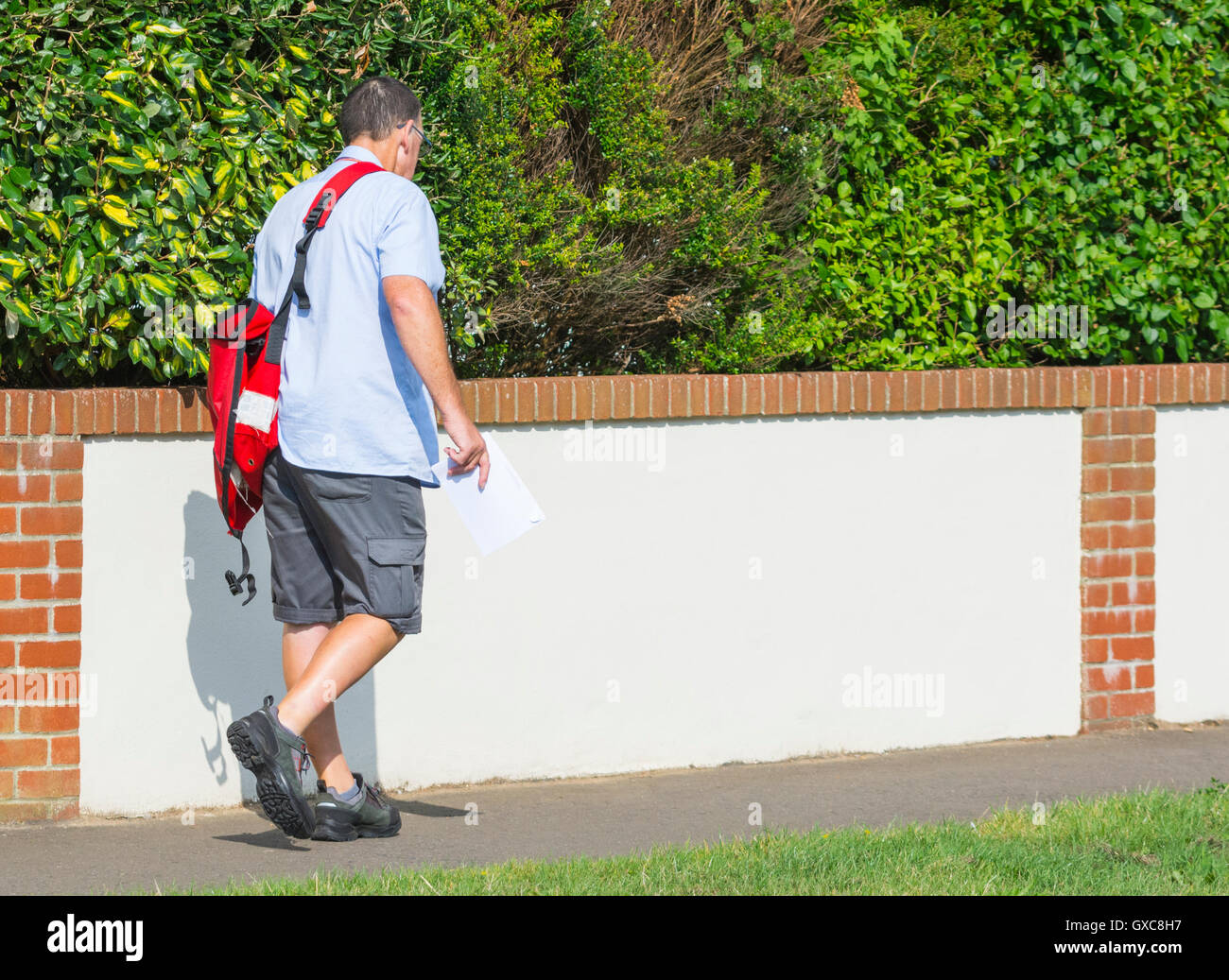 Royal Mail Postbote auf seine Post Lieferung Runden im Vereinigten Königreich. Stockfoto