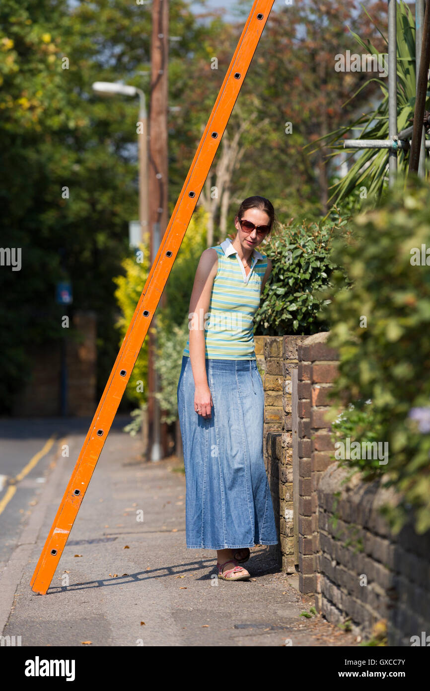 Fußgängerzone / Lady / junge Frau / Menschen / Person laufen unter einer Leiter und Pech in Twickenham, Greater London zu riskieren. UK Stockfoto