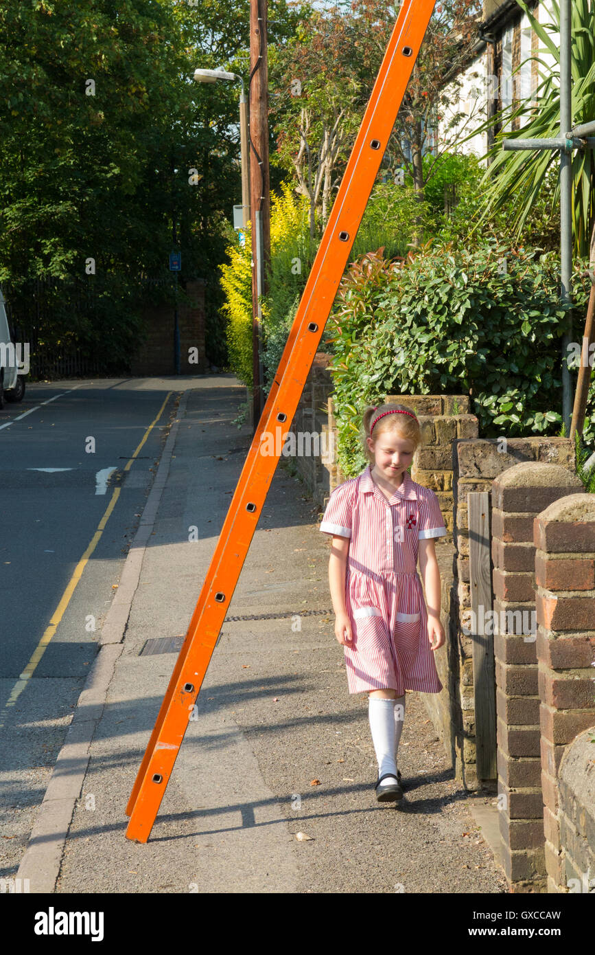 Fußgängerzone / junge Schulmädchen / Kind / Kinder in Uniform / Personen / Person zu Fuss unter Gerüst Leiter, Pech zu riskieren. UK Stockfoto