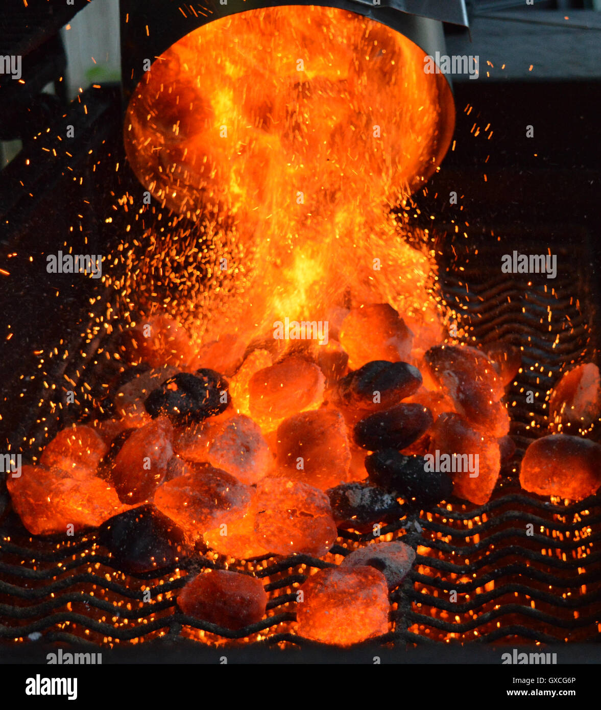 Heiße Kohlen Gießen Sie aus einer Feuer-Starter-Schornstein. Stockfoto
