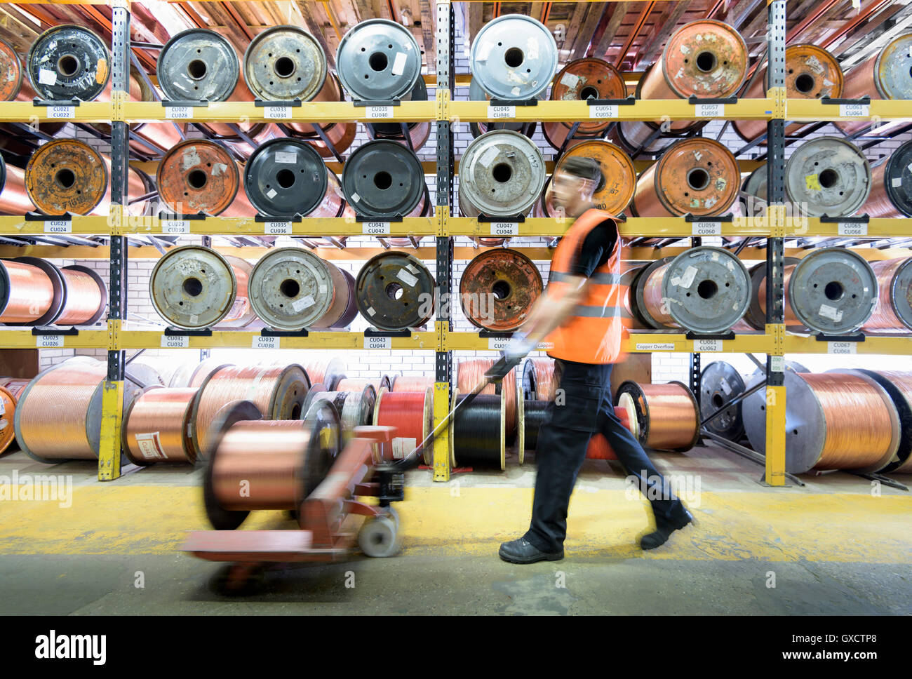 Arbeiter mit Kupferkabel Rollen im Kabelwerk Stockfoto