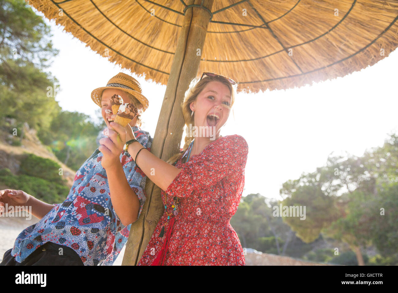 Paar unter Sonnenschirm hält Eistüten, Mallorca, Spanien Stockfoto